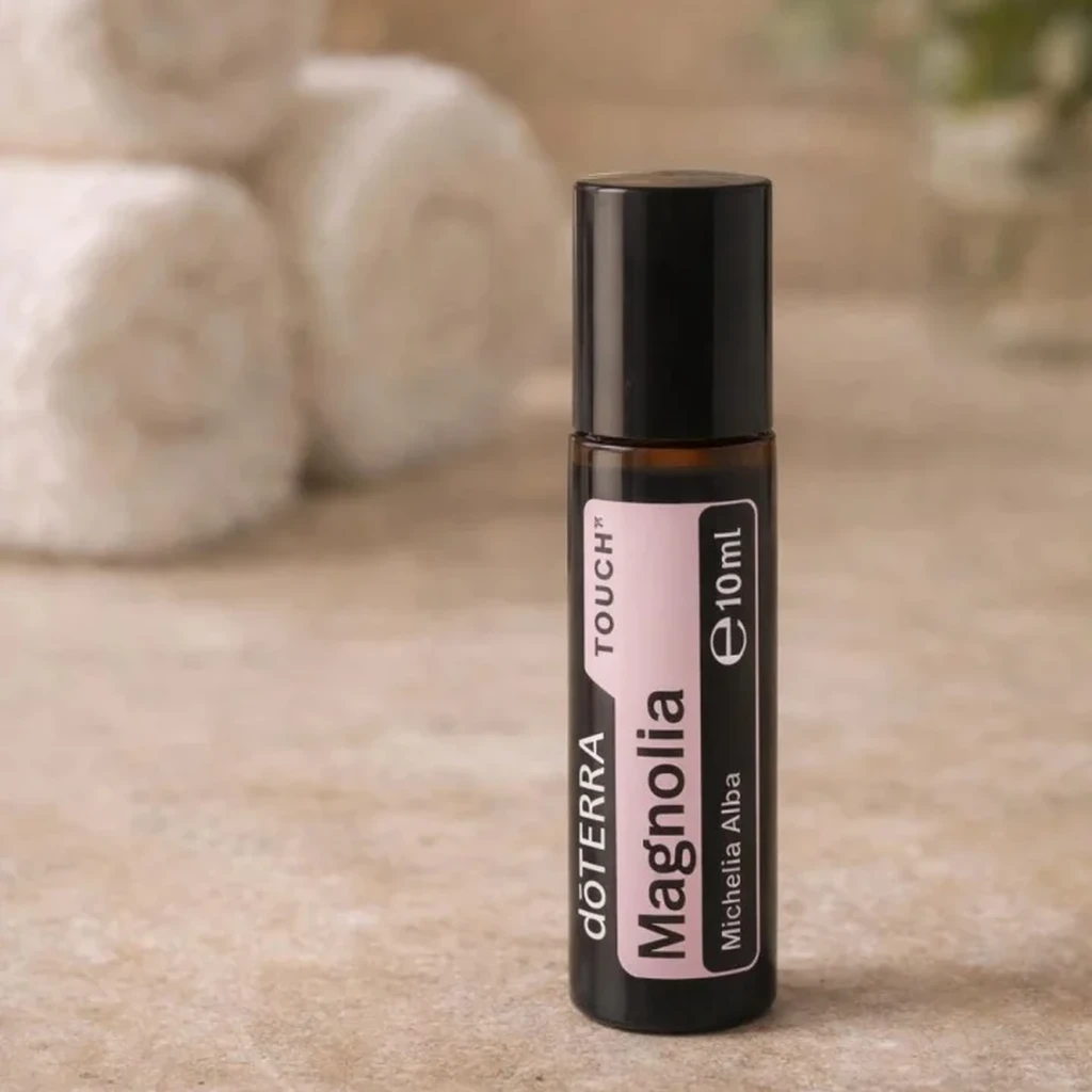 Magnolia Touch doTERRA na kamiennej podstawce obok złożonych ręczników spa