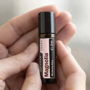 Dłonie trzymające Magnolia Touch doTERRA – aplikacja olejku