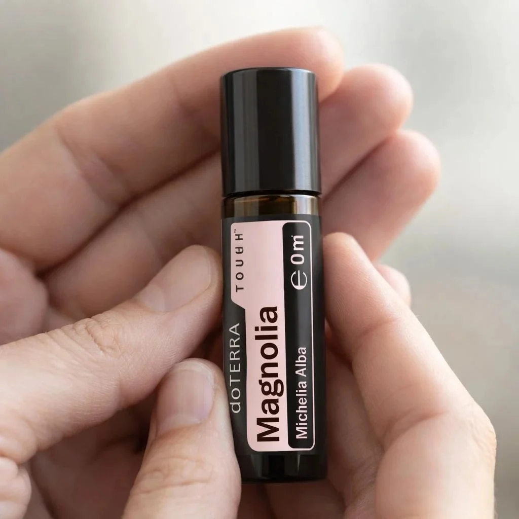 Dłonie trzymające Magnolia Touch doTERRA – aplikacja olejku