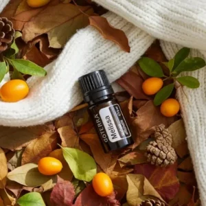 Melisa doTERRA na jesiennej dekoracji z liśćmi i szyszkami