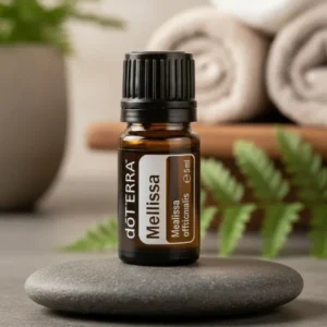 Melisa doTERRA na kamiennej podstawce obok złożonych ręczników spa