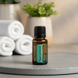 Mięta Zielona (kędzierzawa) doTERRA na kamiennej podstawce obok złożonych ręczników spa