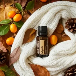 Mirra doTERRA na jesiennej dekoracji z liśćmi i szyszkami