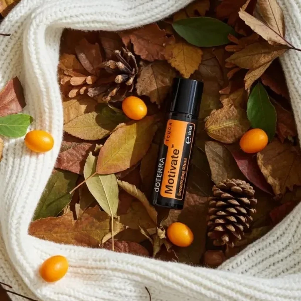 Motivate Touch doTERRA na jesiennej dekoracji z liśćmi i szyszkami