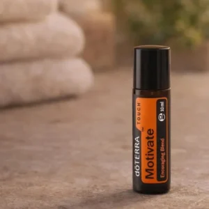 Motivate Touch doTERRA na kamiennej podstawce obok złożonych ręczników spa