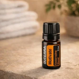Motivate doTERRA na kamiennej podstawce obok złożonych ręczników spa