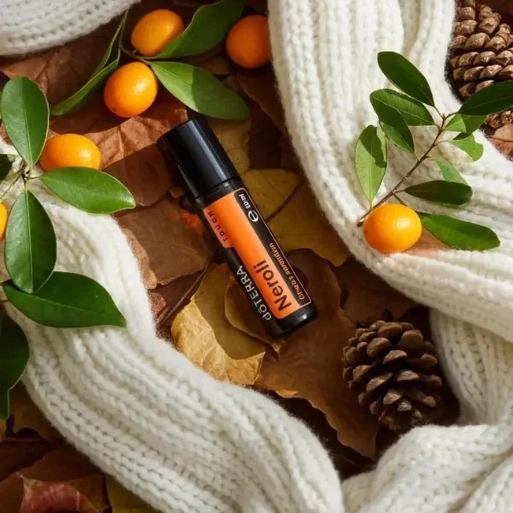 Neroli Touch doTERRA na jesiennej dekoracji z liśćmi i szyszkami