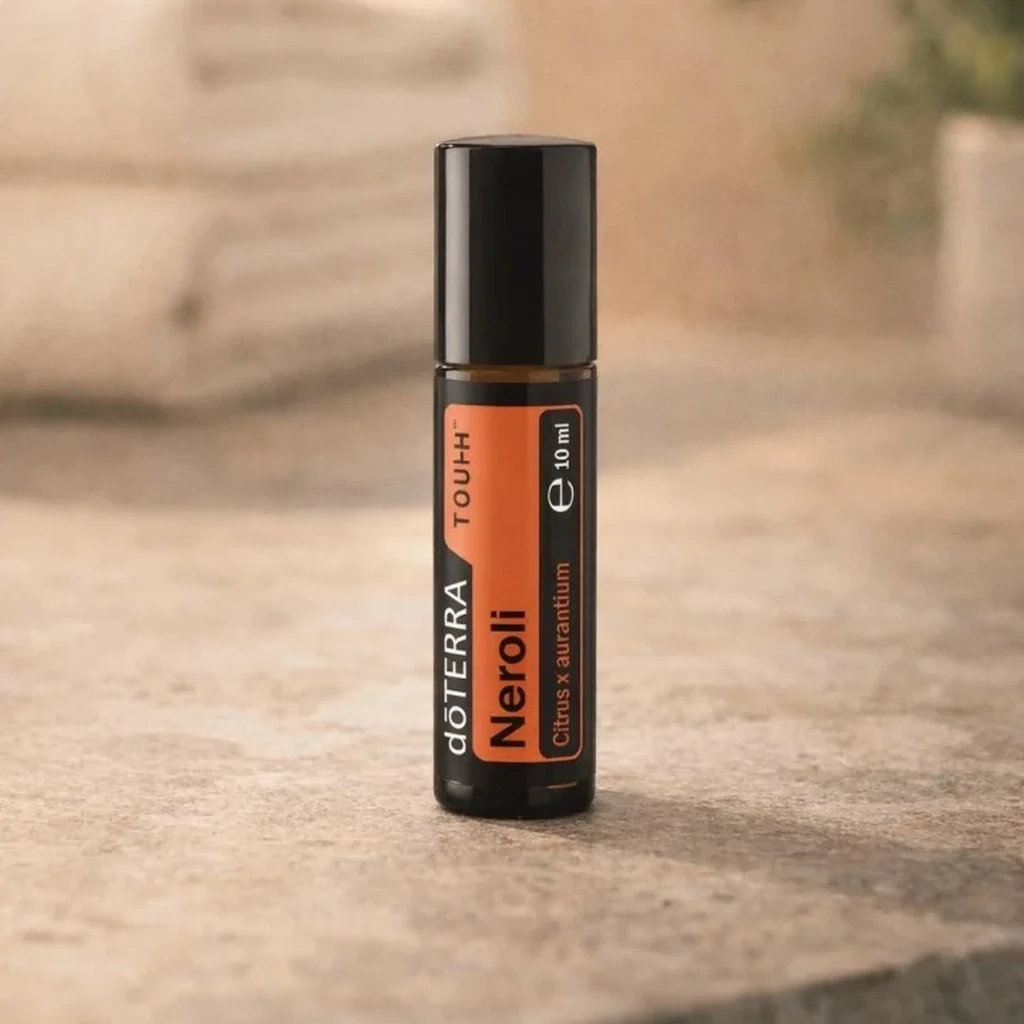 Neroli Touch doTERRA na kamiennej podstawce obok złożonych ręczników spa