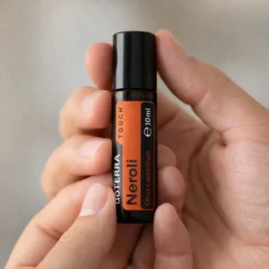 Dłonie trzymające Neroli Touch doTERRA – aplikacja olejku
