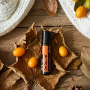 On Guard Touch doTERRA na jesiennej dekoracji z liśćmi i szyszkami