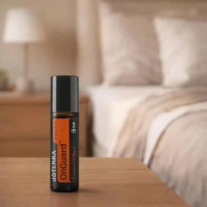 On Guard Touch doTERRA na drewnianym stoliku nocnym przy łóżku