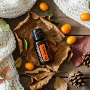On Guard doTERRA na jesiennej dekoracji z liśćmi i szyszkami