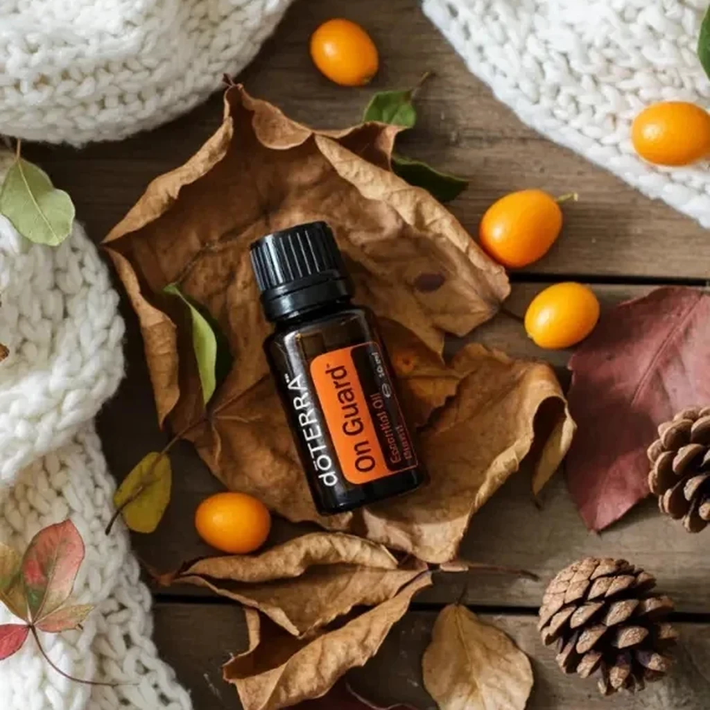 On Guard doTERRA na jesiennej dekoracji z liśćmi i szyszkami