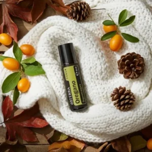 Oregano Touch doTERRA na jesiennej dekoracji z liśćmi i szyszkami