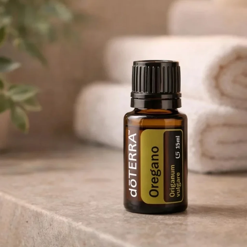 Oregano doTERRA na kamiennej podstawce obok złożonych ręczników spa