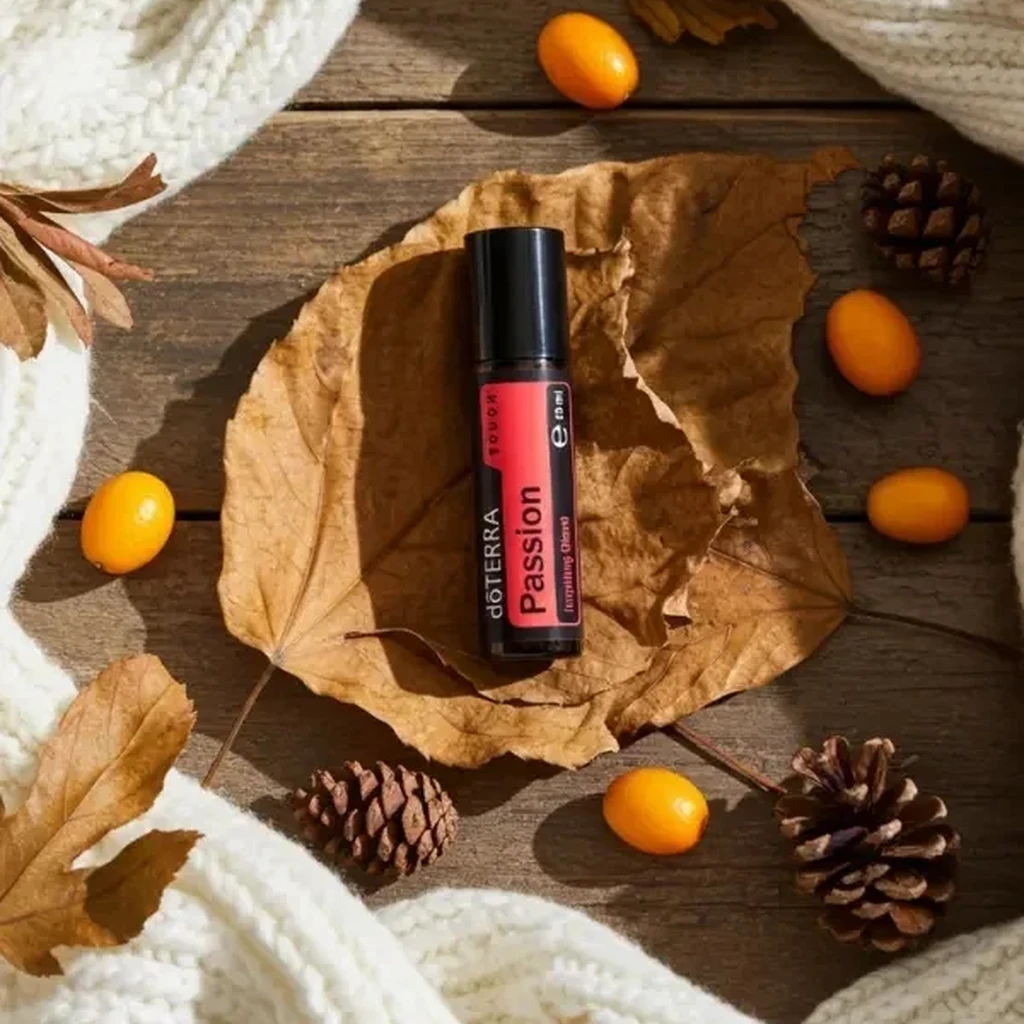 Passion Touch doTERRA na jesiennej dekoracji z liśćmi i szyszkami