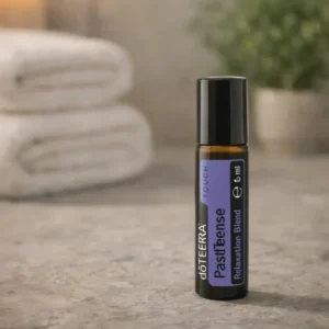Pasttense doTERRA na kamiennej podstawce obok złożonych ręczników spa