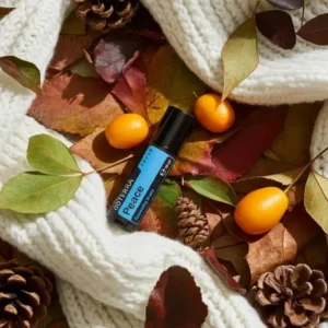 Peace Touch doTERRA na jesiennej dekoracji z liśćmi i szyszkami