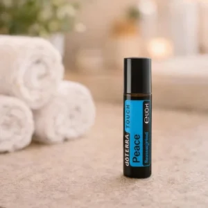 Peace Touch doTERRA na kamiennej podstawce obok złożonych ręczników spa
