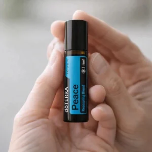 Dłonie trzymające Peace Touch doTERRA – aplikacja olejku