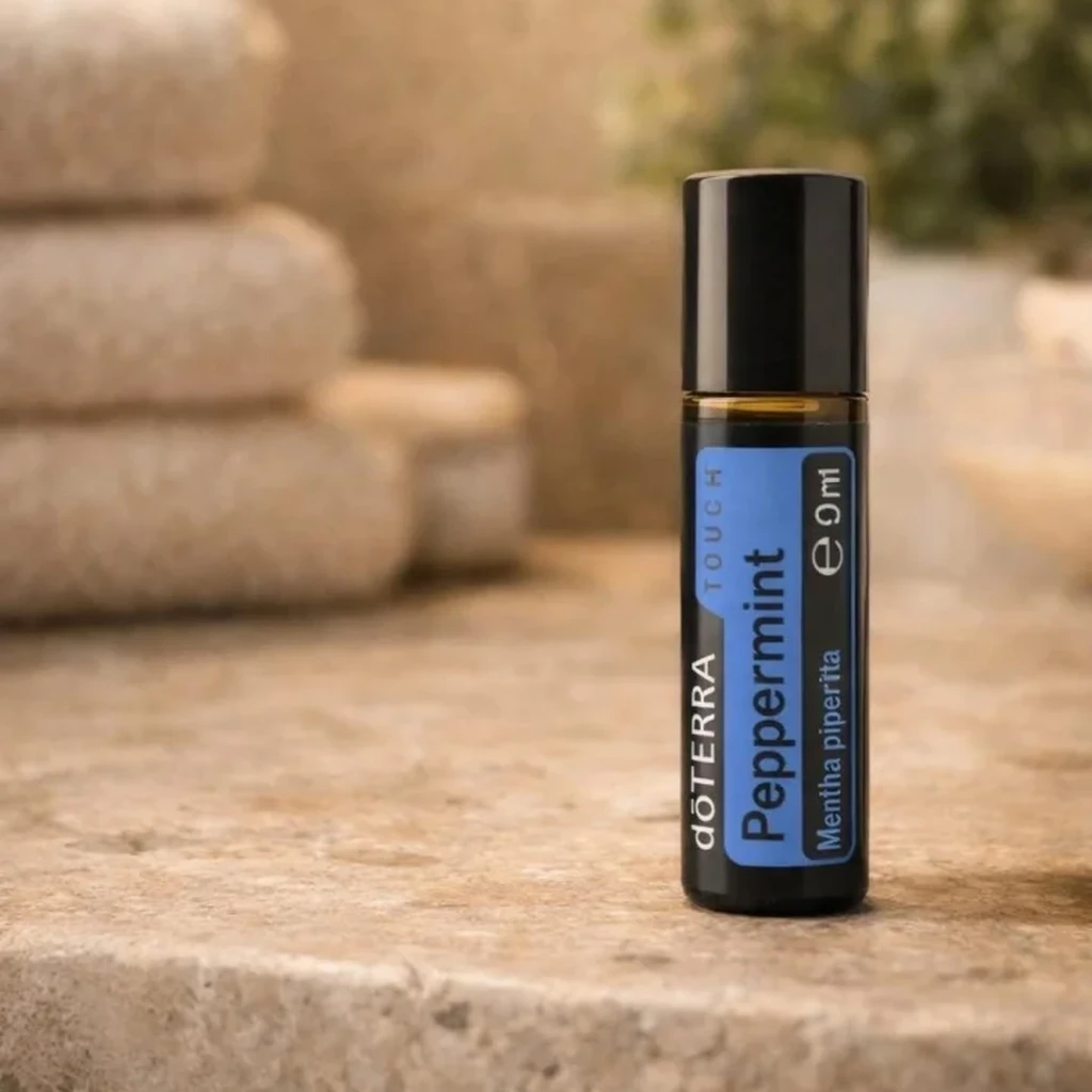 Peppermint Touch doTERRA na kamiennej podstawce obok złożonych ręczników spa