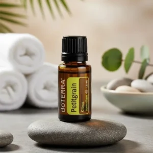 Petitgrain doTERRA na kamiennej podstawce obok złożonych ręczników spa