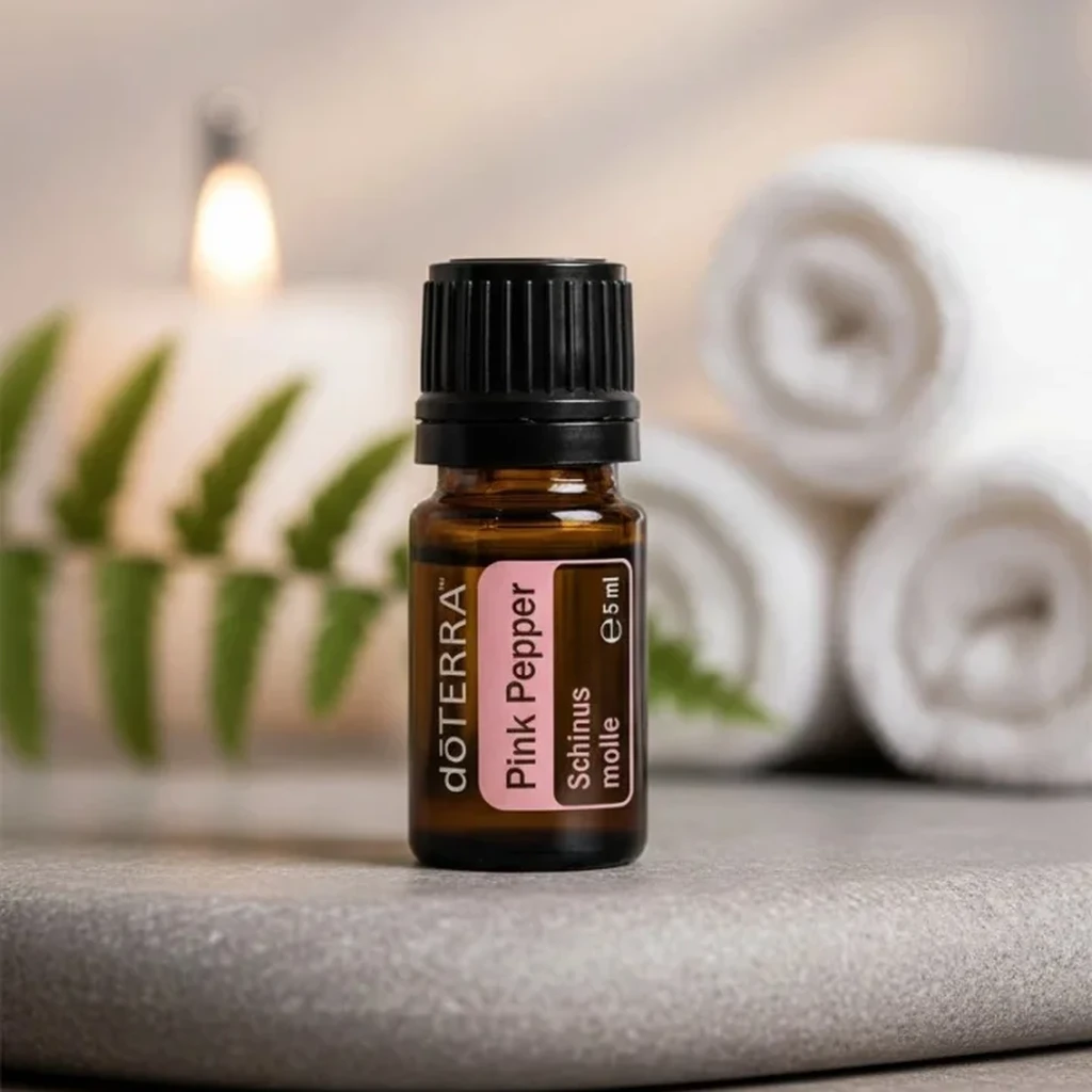 Pieprz Różowy doTERRA na kamiennej podstawce obok złożonych ręczników spa
