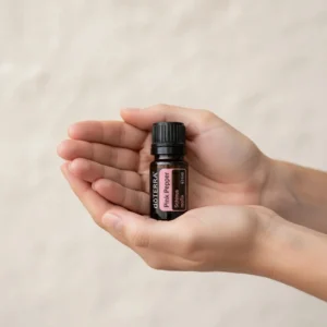 Dłonie trzymające Pieprz Różowy doTERRA – aplikacja olejku