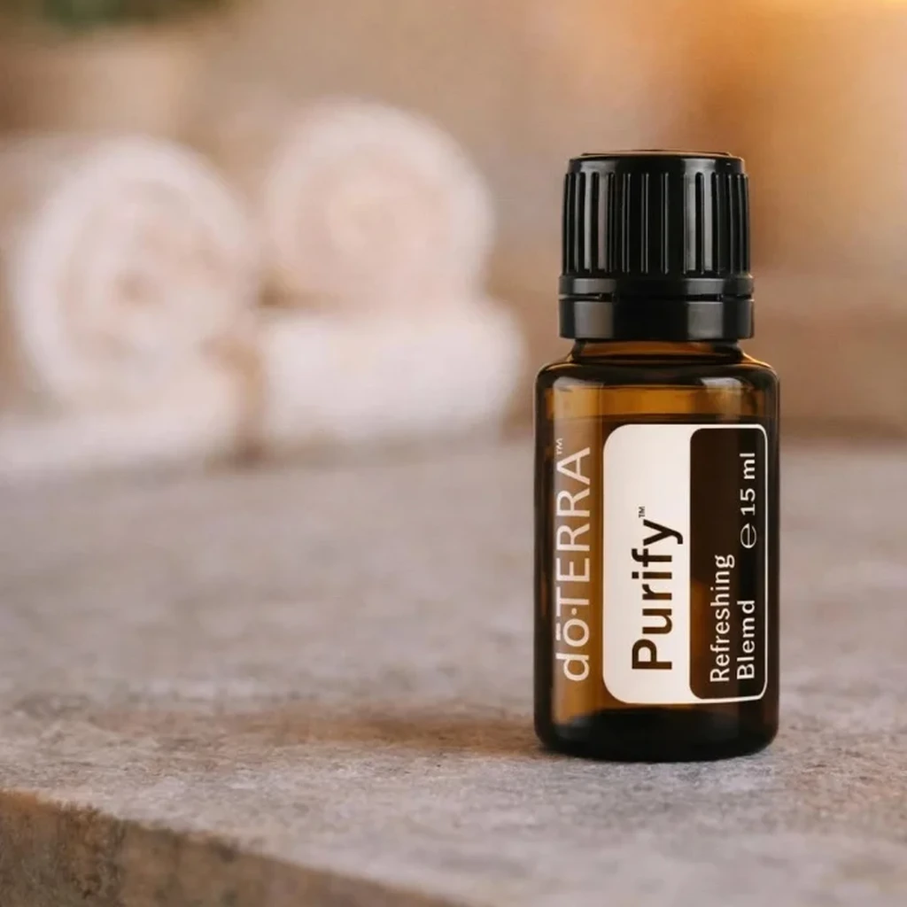 Purify doTERRA na kamiennej podstawce obok złożonych ręczników spa