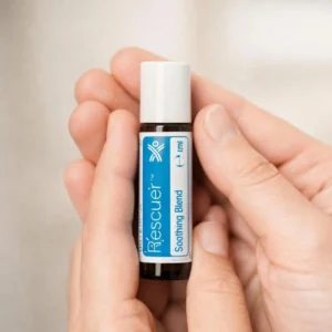 Dłonie trzymające Rescuer doTERRA – aplikacja olejku