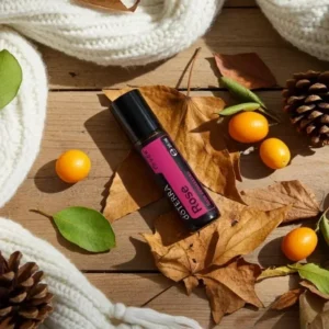 Rose Touch doTERRA na jesiennej dekoracji z liśćmi i szyszkami