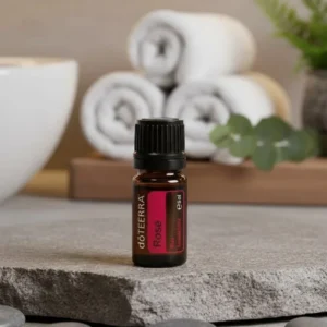 Róża doTERRA na kamiennej podstawce obok złożonych ręczników spa
