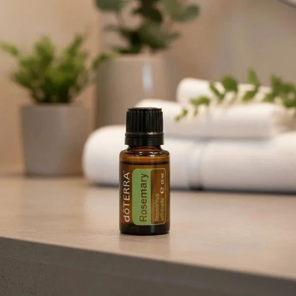 Rozmaryn doTERRA na kamiennej podstawce obok złożonych ręczników spa