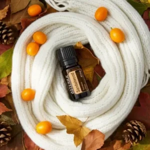 Sandałowiec doTERRA na jesiennej dekoracji z liśćmi i szyszkami