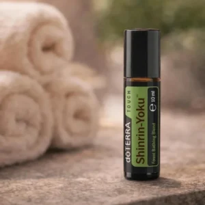 Shinrin-yoku Touch doTERRA na kamiennej podstawce obok złożonych ręczników spa