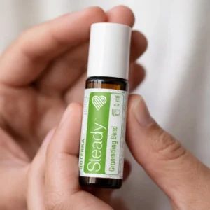 Dłonie trzymające Steady doTERRA – aplikacja olejku