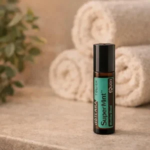 Supermint Touch doTERRA na kamiennej podstawce obok złożonych ręczników spa