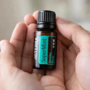 Dłonie trzymające Supermint doTERRA – aplikacja olejku