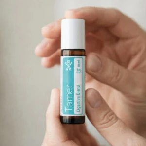 Dłonie trzymające Tamer doTERRA – aplikacja olejku
