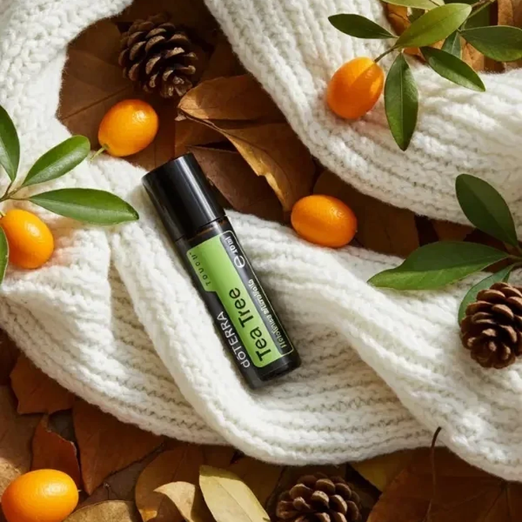 Tea Tree Touch doTERRA na jesiennej dekoracji z liśćmi i szyszkami