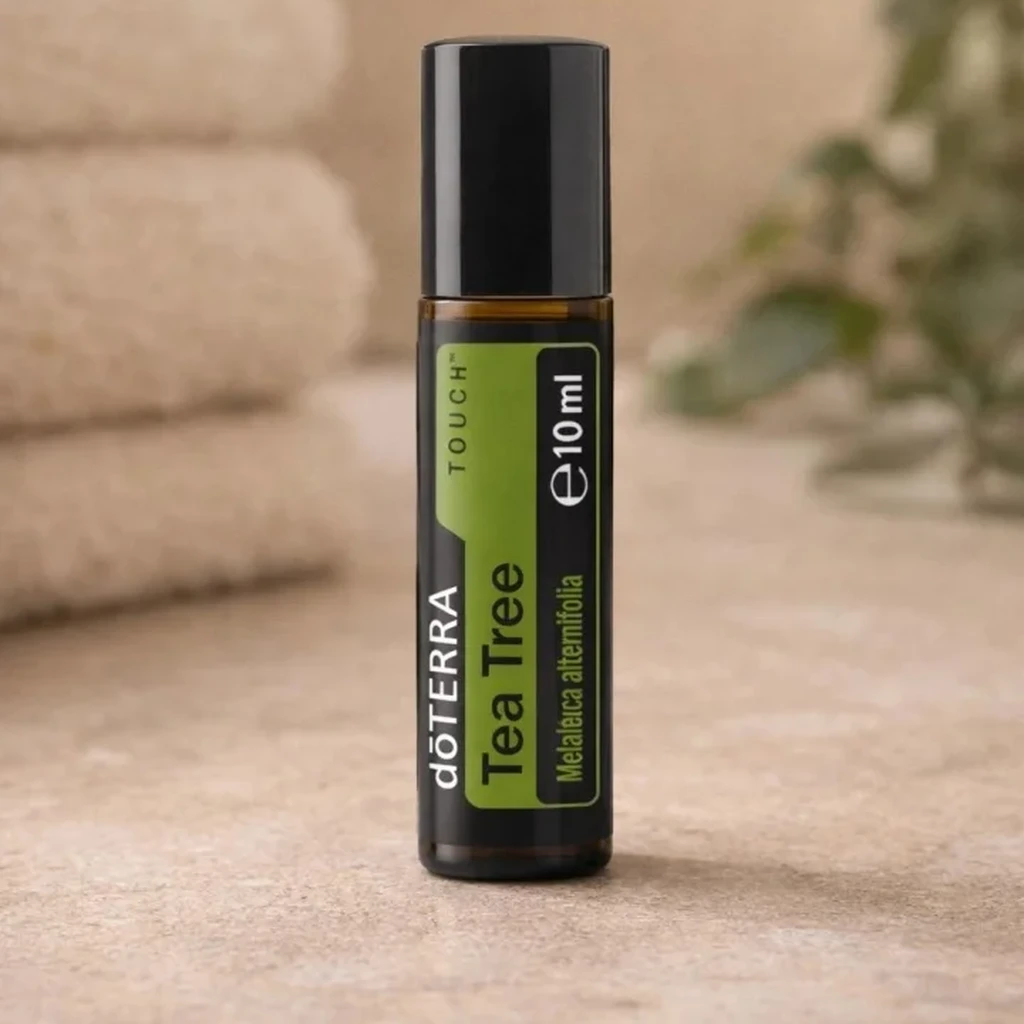 Tea Tree Touch doTERRA na kamiennej podstawce obok złożonych ręczników spa