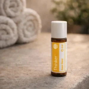 Thinker doTERRA na kamiennej podstawce obok złożonych ręczników spa