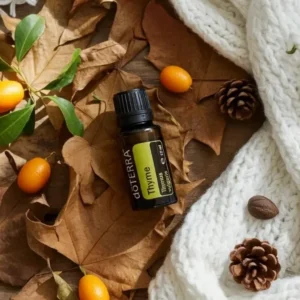 Tymianek doTERRA na jesiennej dekoracji z liśćmi i szyszkami