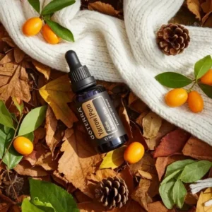 Yarrow Pom doTERRA na jesiennej dekoracji z liśćmi i szyszkami