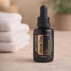 Yarrow Pom doTERRA na kamiennej podstawce obok złożonych ręczników spa