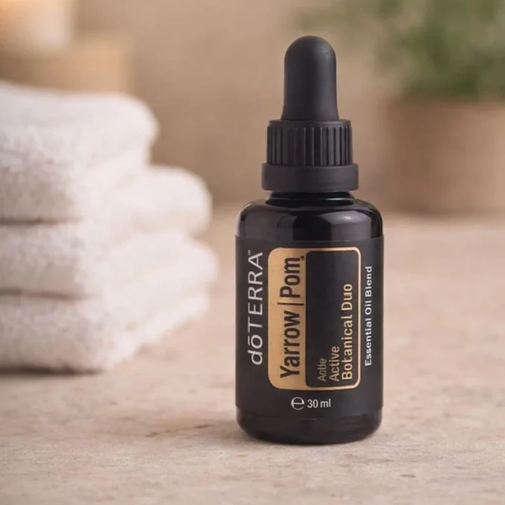 Yarrow Pom doTERRA na kamiennej podstawce obok złożonych ręczników spa