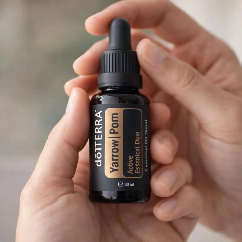 Dłonie trzymające Yarrow Pom doTERRA – aplikacja olejku
