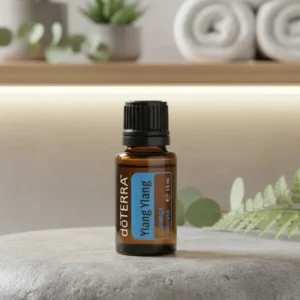 Ylang Ylang doTERRA na kamiennej podstawce obok złożonych ręczników spa