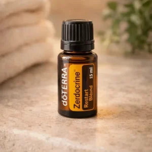 Zendocrine doTERRA na kamiennej podstawce obok złożonych ręczników spa