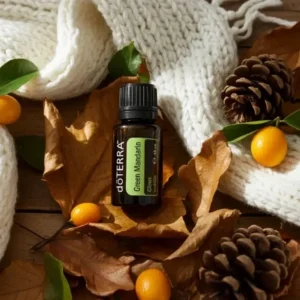 Zielona Mandarynka doTERRA na jesiennej dekoracji z liśćmi i szyszkami